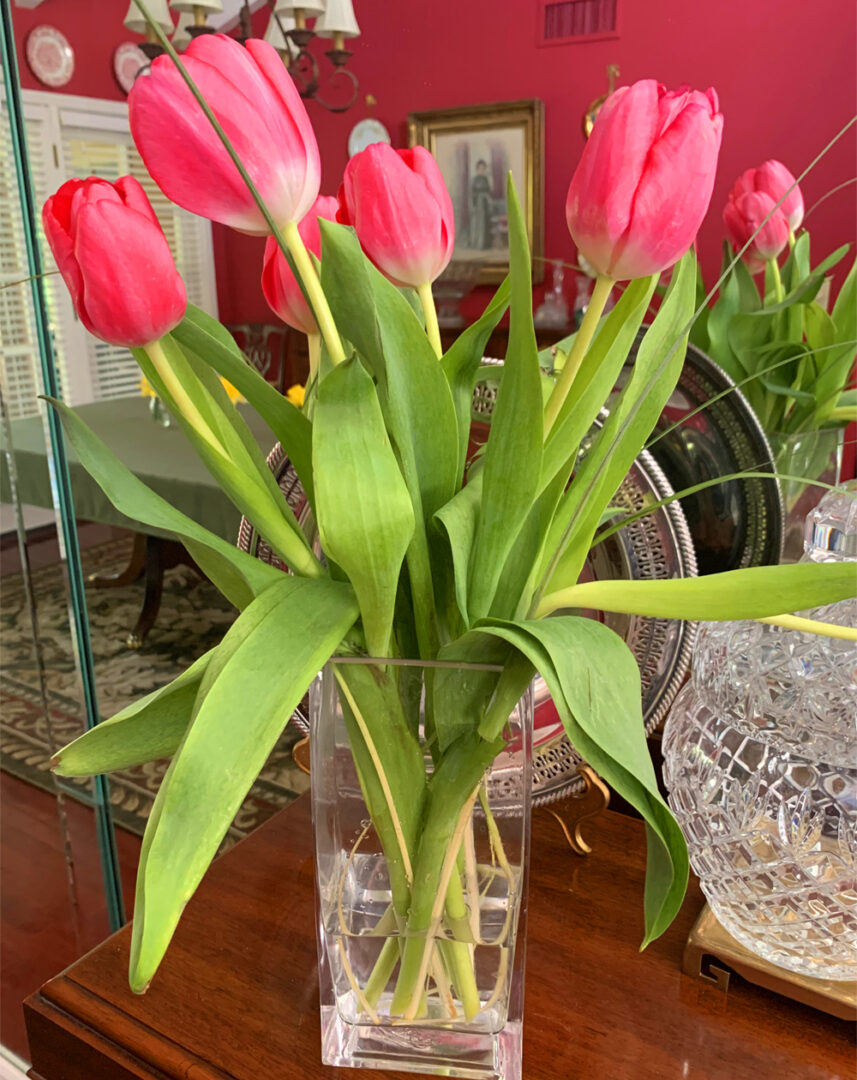 A vase of pink flowers on top of a table.